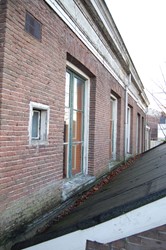<p>Overzicht van het middelste deel van de gevel met geheel links een later ingehakt venster van het achterliggende privaat/toilet. </p>

